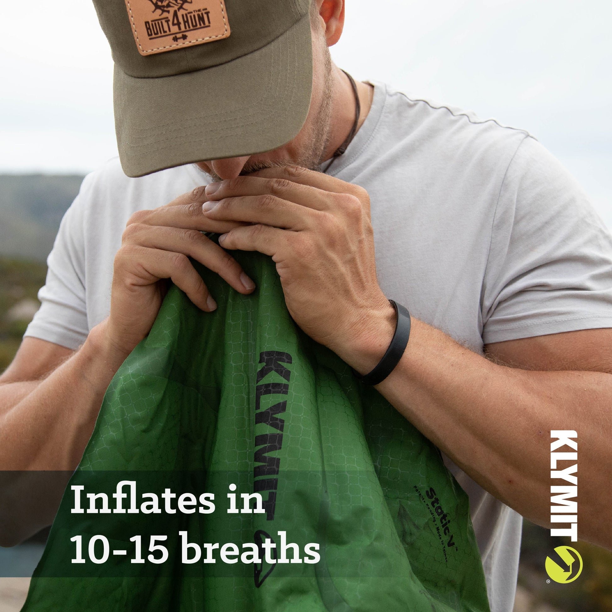 A man is inflating the Static V sleeping pad. Text on the image reads: Inflates in 10-215 breaths.